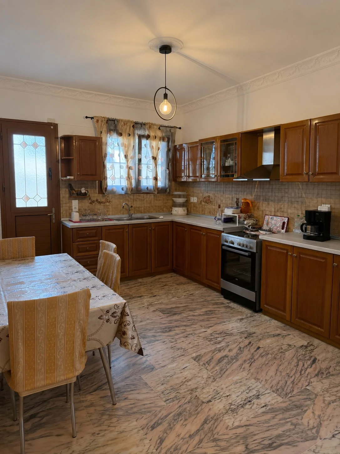 Fully-equipped Kitchen with stove, sink, dining area and coffee machine