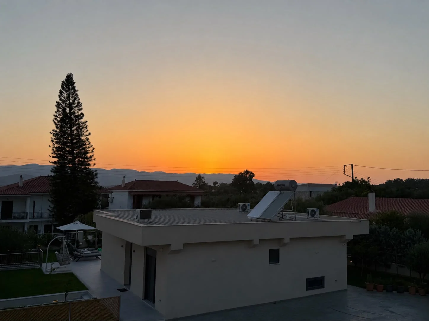 The sun setting over the rooftops and hills, seen from the wrap-around balcony